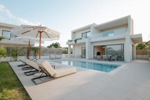 a villa with a pool and chairs and an umbrella at SOLEIL LUXURY VILLAS in Lithakia
