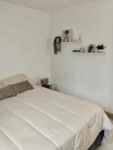 un lit blanc dans une chambre avec un mur blanc dans l'établissement Casa de la Sierra, à Santa Marta 6 autres photos