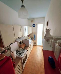 cocina con fogones en una habitación en La casa di nonna Lina al mare - senza barriere, en Torre del Lago Puccini
