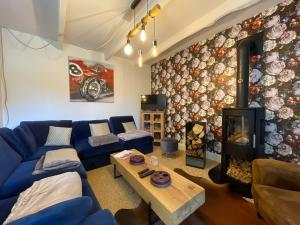 a living room with a blue couch and a fireplace at Gîte de charme in Paimpol