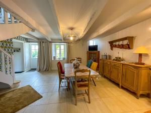 una cucina e una sala da pranzo con tavolo e sedie di Gîte de charme a Paimpol