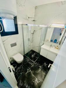 a bathroom with a glass shower and a toilet at Caesar Resort Apartments Marcellus 51 in Iskele