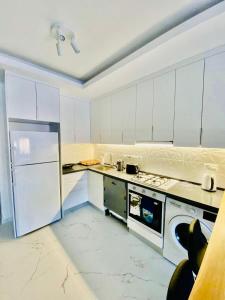 a white kitchen with a stove and a refrigerator at Caesar Resort Apartments Marcellus 51 in Iskele