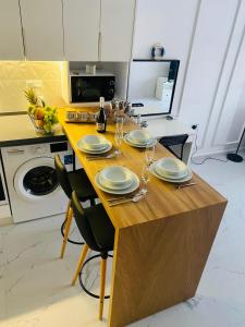 a kitchen with a table with plates and wine glasses at Caesar Resort Apartments Marcellus 51 in Iskele