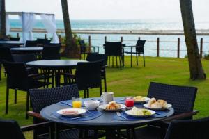 a table with plates of food on it with a view of the ocean at Porto Alto Resort ap 213 in Cupe