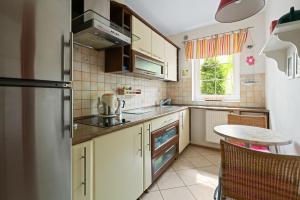 una cucina con un frigorifero e un tavolo di Apartamenty HoliApart Żeromskiego 2, przy plaży, przyjazny czworonogom a Krynica Morska