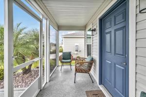 a porch with a blue door and a chair at King Sized Comfort in The Village of Deluna in The Villages