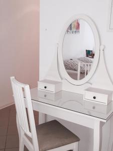 a white dressing table with a mirror and a chair at Pension Lindenhof in Limburg an der Lahn