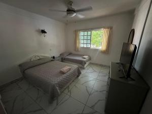 a bedroom with a bed and a television in it at Hotel Cancún Rosa in Cancún