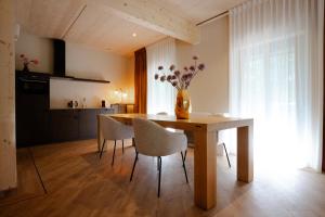 a dining room table with chairs and a vase with flowers at Hotel Bent in Oisterwijk