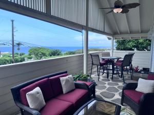 a porch with a couch and a table and chairs at Pines182 in Kailua-Kona