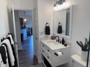 a white bathroom with a sink and a mirror at Pines182 in Kailua-Kona +30 photos