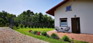 a house with two chairs next to a yard at JAWORNICA HOUSE domek z pięknym widokiem in Targanice