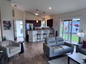 a living room with a couch and chairs and a kitchen at Pines182 in Kailua-Kona
