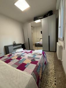 Un dormitorio con una cama con una colcha encima en Venice Station Guest House, en Venecia