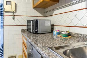 a kitchen counter with a microwave and a sink at Trilocale in centro con parcheggio gratuito 4 persone in Trino