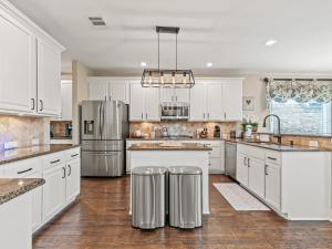 a kitchen with white cabinets and stainless steel appliances at The Sapphire Sanctuary with Pool in Allen