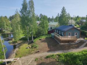 a house with a solar roof next to a river at Saimaan Kodikas rantatalo in Savonlinna