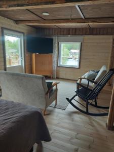 a bedroom with a bed and a couch and a chair at Saimaan Kodikas rantatalo in Savonlinna