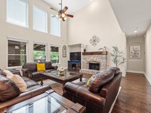 a living room with leather furniture and a fireplace at The Sapphire Sanctuary with Pool in Allen