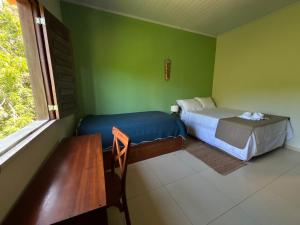 a bedroom with a bed and a table and a window at Casa Igarapé Atins in Atins +18 photos