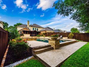 a backyard with a swimming pool and a fence at The Sapphire Sanctuary with Pool in Allen
