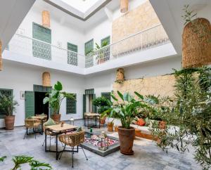 a large room with tables and chairs and plants at Riad Villa Wengé & Spa in Marrakech