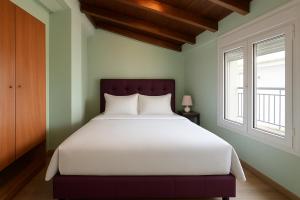 Un dormitorio con una cama grande y dos ventanas. en Sea Green House, en Orfánion
