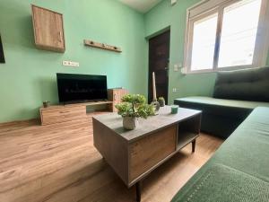 Una sala de estar con un sofá y un televisor. en Sea Green House, en Orfánion