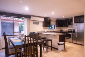 a kitchen and dining room with a table and a counter top at The Cove Door 15 and 16 Upper & Lower Unit in Ocotal