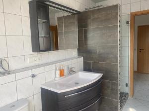 a bathroom with a sink and a mirror at Ferienwohnung Daniels in Hümmel +7 photos