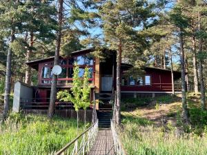 AlajõeVesiroos Villa的树林中的房屋,有楼梯通往