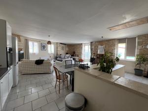 a large living room with a kitchen and a living room at Gîte de l'hortensia-Charmante maison de campagne au calme in Gourville