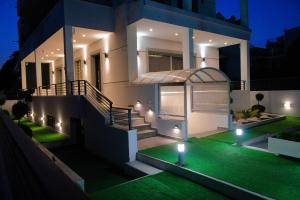 a house with a green lawn in front of it at night at Keti's Elite in Athens