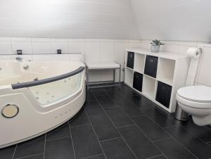 a bathroom with a bath tub and a toilet at Ferienhaus Lina in Südbrookmerland