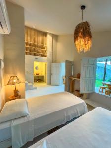 a bedroom with two beds and a chandelier at KANAHA BEACH VILLA in Icaraí