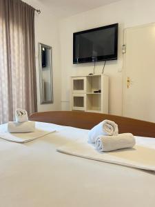 a hotel room with towels on a bed with a television at Villa Mare in Makarska