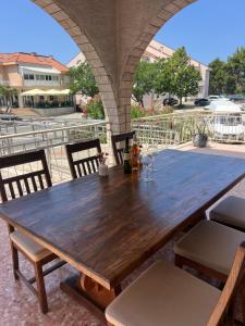 a wooden table on an outdoor patio with chairs at Villa Mare in Makarska