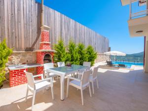 a patio with a table and chairs and a fireplace at villa vista çukurbağ in Cukurbag