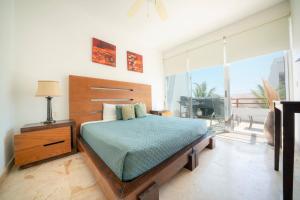 a bedroom with a bed and a large window at Beachfront Penthouse with 3 Bedrooms & Ocean View - Las Nubes in Playa del Carmen
