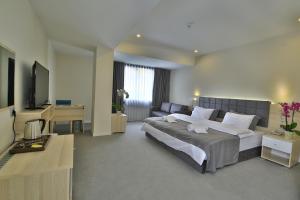 Un dormitorio con una cama grande y un escritorio. en leto city hotel, en Eskisehir 97 fotos más