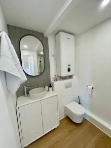 Un baño blanco con inodoro y espejo. en Appartement Gare 2 Personnes, en Le Mans