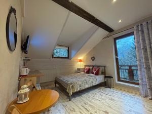 a bedroom with a bed and a table at Willa Avita in Karpacz