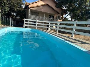 ein blauer Swimmingpool vor einem Haus in der Unterkunft Pousada Rio Cipó in Serra do Cipo