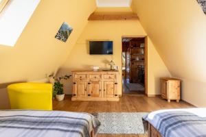 Schlafzimmer im Dachgeschoss mit 2 Betten und einem TV in der Unterkunft Domek Stroma 13 in Zakopane