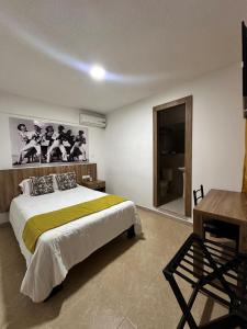 a bedroom with a large bed with a desk and a desk at Santander Hotel Boutique in Quevedo