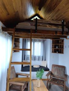 Letto a castello in una camera con tavolo e sedie di Tiny House Nativa a Montecarlo