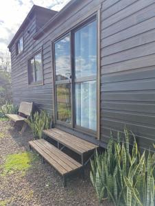 una casa con una panca di legno e una finestra di Tiny House Nativa a Montecarlo Altre 18 foto