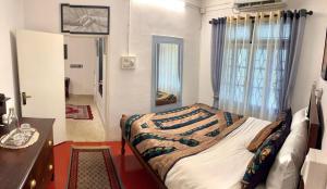 a bedroom with a bed and a desk and a window at Scarlet's Cottage & Tea Garden in Cochin