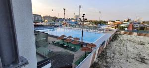 a swimming pool with tables and chairs next to a building at Apartmani Marjanovic in Jagodina